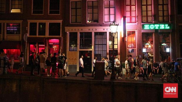 Para PSK menjajakan diri melalui pintu berkaca di red light district De Wallen, Amsterdam.