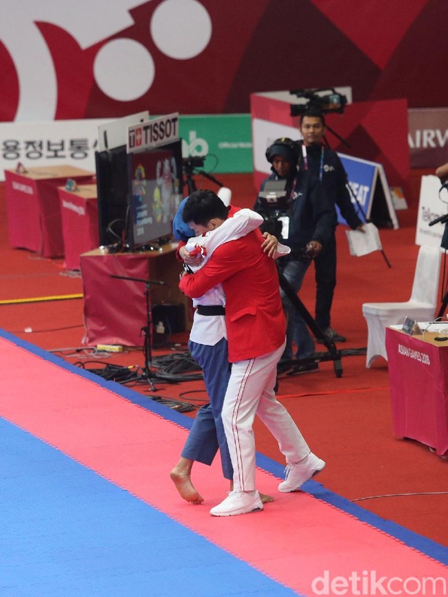 Defia yang berlaga dalam balutan hijab biru tak dapat menahan tangis harunya setelah memenangkan final taekwondo dengan poin 8.960. Lawannya, Marjan dari Iran meraih poin 8.470. (Foto: Grandyos Zafna/detikSport)