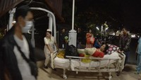 Petugas medis memindahkan pasien dari ruang perawatan ke luar ruangan usai terjadi gempa di RSUP Sanglah, Denpasar, Bali, Minggu (19/8). ANTARA FOTO/Fikri Yusuf.