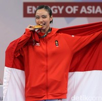 Dari cabang wushu, ada atlet cantik Lindswell Kwok yang menyumbangkan medali emas untuk Indonesia di Asian Games 2018. Dalam balutan jaket merah, Lindswell memasang senyum manis sambil menggigit medali perolehannya. Foto: Agung Pambudhy