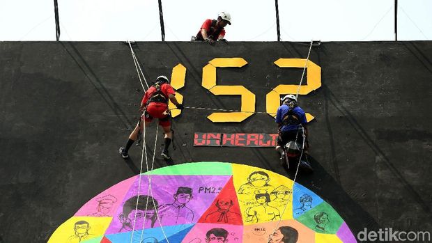 Para relawan Greenpeace memasang spanduk raksasa soal kualitas udara di Jakarta.