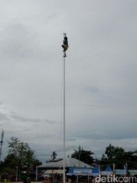 Aksi Reza Mangar memanjat tiang bendera.