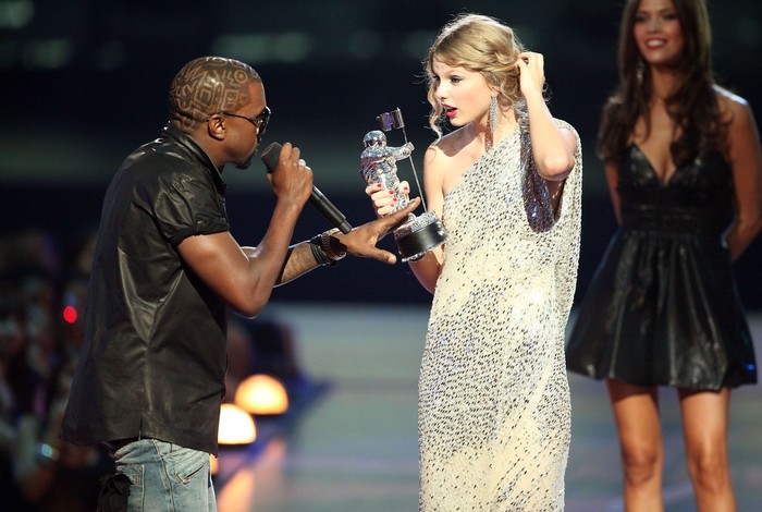 Kanye West dan Taylor Swift NEW YORK - SEPTEMBER 13: Kanye West (L) jumps onstage after Taylor Swift (C) won the Best Female Video award during the 2009 MTV Video Music Awards at Radio City Music Hall on September 13, 2009 in New York City. (Photo by Christopher Polk/Getty Images)