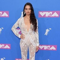 Shanina Shaiq belakangan terjun ke dunia televisi. Bintang Model Squad tersebut mengenakan jumpsuit renda putih transparan rancangan Naeem Khan di karpet merah MTV VMAs 2018. Foto: Getty Images
