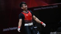 Senyum Deni setelah sukses mengangkat beban di cabang angkat besi kelas 69 kg.