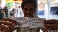 Warga menunjukkan kupon pembagian daging kurban.