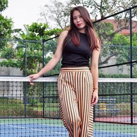 Memiliki lebih dari 172 ribu pengikut di Instagram, Sheila kerap mengunggah fotonya saat off the field atau ketika tidak bertanding voli. Seperti di foto ini, dia bergaya dengan celana lurus garis-garis dengan atasan hitam tanpa lengan. Foto: Dok. Instagram Berllian Marsheilla