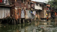 Petugas mengangkat sampah yang mengapung di atas air.