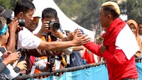Atlet paralayang putra Indonesia Jafro Megawanto menyalami pendukungnya, setelah dipastikan merebut medali emas untuk katagori perorangan putra nomor ketepatan mendarat, Asian Games2018 di Cisarua, Puncak, Bogor, Jawa Barat, Kamis (23/8). ANTARA FOTO/INASGOC/Crack Palinggi.