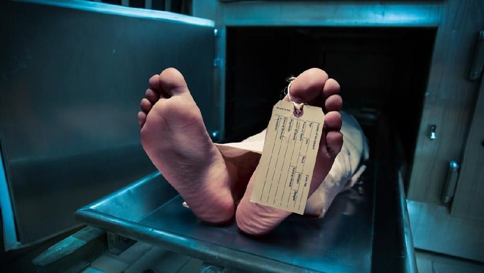 Grungy photo of feet with toe tag on a morgue table
