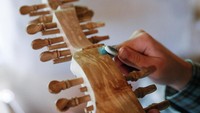 Fedynsky sedang membuat alat musik tradisional khas Ukraina bernama torban. Pria 43 tahun itu mengatakan upayanya untuk melestarikan seni musik tradisional Ukraina membuatnya harus mengenal alat-alat musik tersebut, membuat penelitian panjang, mengunjungi museum hingga mempelajari proses pembuatan instrumen, sehingga tak asal dalam proses pembuatannya. Valentyn Ogirenko/Reuters.