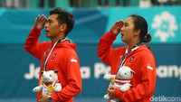 Christopher Rungkat dan Aldila Sutjiadi memberikan penghormatan saat lagu Indonesia Raya dikumandangkan di arena Tennis Court Center, Jakabaring Sport City, Palembang.