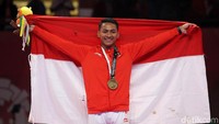 Zigi mengibarkan bendera merah putih di atas podium usai meraih medali perunggu.