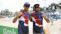 Gilang dan Danang berpose bersama sambil mengepalkan tangannya usai mengalahkan tim voli pantai putra Oman.