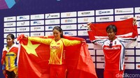 Wiji Lestari yang meraih medali perunggu naik ke podium sambil mengibarkan bendera merah putih.