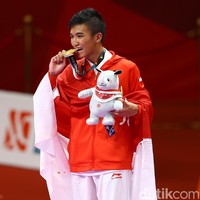 Karateka Rifki Ardiansyah Arrosyid juga menyumbangkan medali emas di kategori kumite 60 kg, setelah menang atas karateka Iran Amir Mahdi Zadeh. Ia berpose dengan menggigit sedikit pinggiran medali emasnya. Foto: Grandyos Zafna
