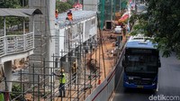 Para pekerja menyelesaikan pembangunan halte busway pengganti di halte Setuabudi Utara Aini, Jl Rasuna Said, Jakarta, Minggu (26/08/2018).