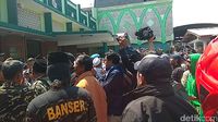 Pria beratribut Banser ikut aksi penolakan deklarasi #2019GantiPresiden di Masjid Kemayoran, Surabaya.