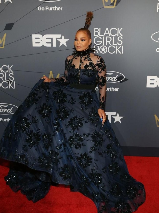 Penyanyi 52 tahun itu muncul dalam balutan gaun gelap dengan rok megar dramatis. Gaun bermotif floral itu hadir dalam bahan transparan yang mengekpos bahu dan lengan Janet. (Foto: Manny Carabel/Getty Images)