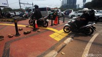 Pengendara sepeda motor menerobos jalur pejalan kaki untuk menghindari kemacetan.