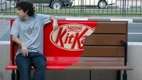 Perusahaan cokelat KitKat membuat kursi umum tampil seperti cokelat yang siap dimakan. Kemasan pembungkusnya sudah dibuka sebagian dan kelihatan bagian cokelatnya. Mau duduk kok kesannya seperti menduduki cokelat. Foto: Istimewa