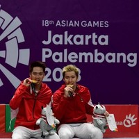 Kalau ini aksi Kevin Sanjaya Sukamuljo dan Marcus Fernaldi Gideon gigit medali, setelah menang dari Fajar Alfian/Muhammad Rian Ardianto di All Indonesian Final ganda putra Asian Games 2018. Rasa bangga tampak terlihat dari wajah Kevin dan Marcus. Foto: Sonny Tumbelaka/AFP Photo