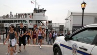 Para pengunjung yang dievakuasi dibawa ke Pulau Ellis yang letaknya paling dekat dengan Pulau Liberty. Mereka berharap untuk bisa kembali ke Pulau Liberty usai api dipadamkan. Foto: REUTERS/Andrew Kelly