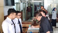 Pollycarpus yang didampingi istrinya mengisi buku tamu Bapas Bandung.