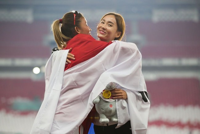 Cantiknya Jung Hyelim saat berpelukan dengan atlet lari Indonesia Emilia Nova yang pada cabang lari halang rintang 100 meter Asian Games 2018 meraih medali perak. Foto: Getty Images