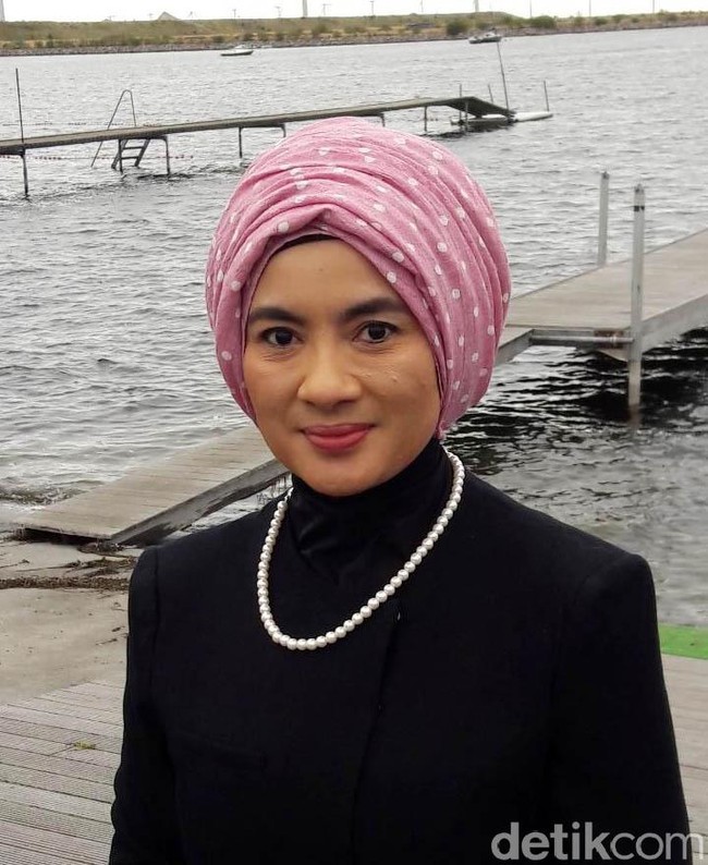 Turban pink menjadi pilihan Nicke untuk membuat penampilannya lebih segar saat mengenakan busana berwarna hitam. Untuk menutupi lehernya, dia memakai busana berkerah tinggi. Foto: Erwin Dariyanto/detikcom