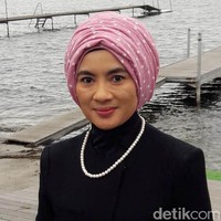 Turban pink menjadi pilihan Nicke untuk membuat penampilannya lebih segar saat mengenakan busana berwarna hitam. Untuk menutupi lehernya, dia memakai busana berkerah tinggi. Foto: Erwin Dariyanto/detikcom