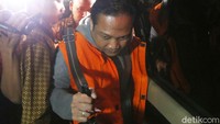 Dia tak bicara apapun saat dibawa masuk ke mobil tahanan.