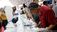 Warga tampak asyik memilah kaus khas Asian Games.