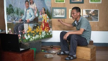 Seniman Jon Rying Guk tengah melukis di studionya. Foto: Carl Court / Getty Images