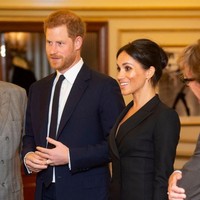 Pangeran Harry tampil formal dengan setelan biru navy berjas dengan kemaja putih yang dipadu dasi senada. Sementara itu, Meghan menyenadakan penampilannya dengan dress hitam dari label Judith & Charles. (Foto: Getty Images)