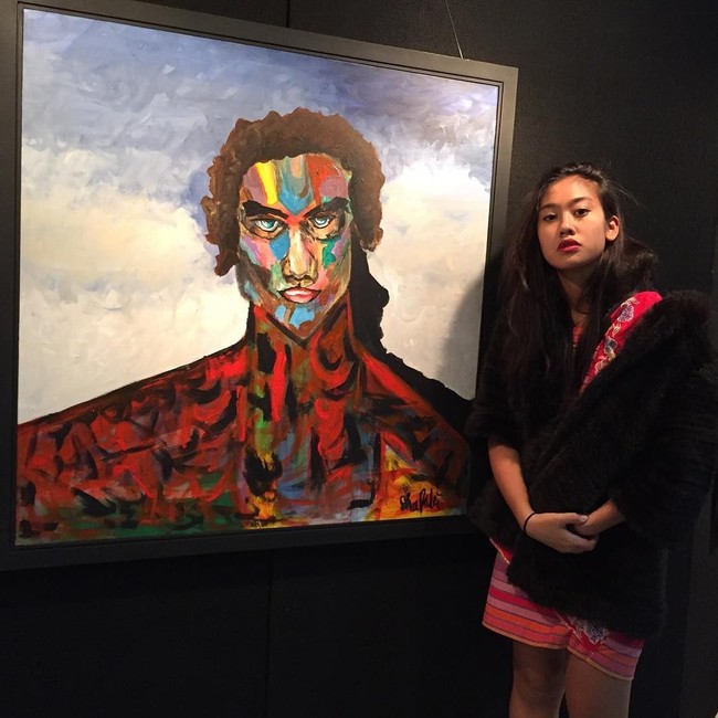Ketika menggelar pameran lukisannya, Shafa mengandalkan dress kemerahan bergaya etnik yang dipadukan dengan mantel berbulu.(Foto: Instagram/@shafa_fadli)