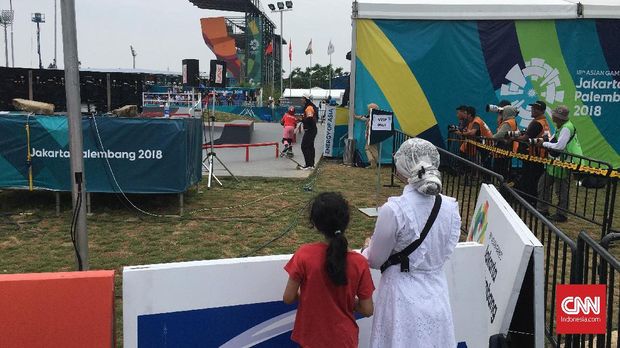 Nin Hardi tetap setia menyaksikan buah hatinya bertanding meski di bawah terik matahari.