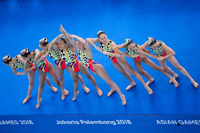 Tim renang artistik Jepang mengenakan busana renang tabrak warna dan motif saat berkompetisi di kategori Free Routine. Warna-warna kontras banyak dipakai sebagai busana renang artistik agar terlihat menonjol saat digunakan di dalam kolam renang. Foto: Getty Images