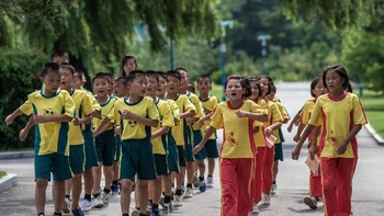 Anak-anak bernyanyi sembari melakukan kegiatan baris-berbaris. Foto: Carl Court / Getty Images