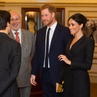Meghan lalu menyempurnakan gaun seharga US$ 595 atau sekitar Rp 9 juta itu dengan clutch emas kotak, berikut pointed-heels hitam yang menopang kakinya. (Foto: Getty Images)