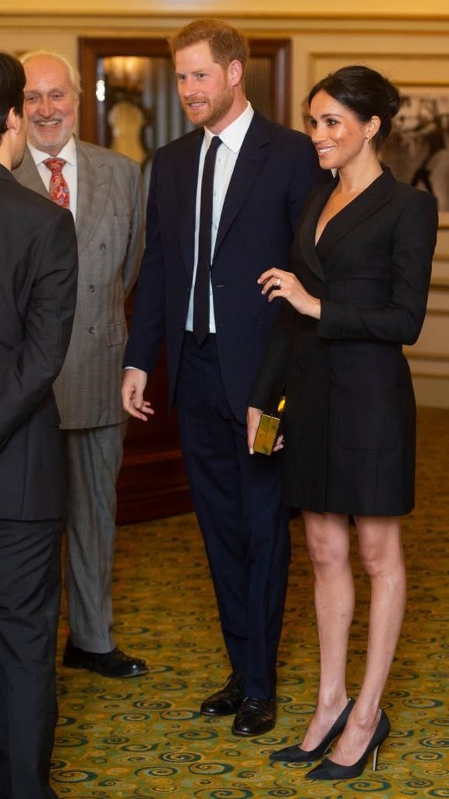 Meghan lalu menyempurnakan gaun seharga US$ 595 atau sekitar Rp 9 juta itu dengan clutch emas kotak, berikut pointed-heels hitam yang menopang kakinya. (Foto: Getty Images)