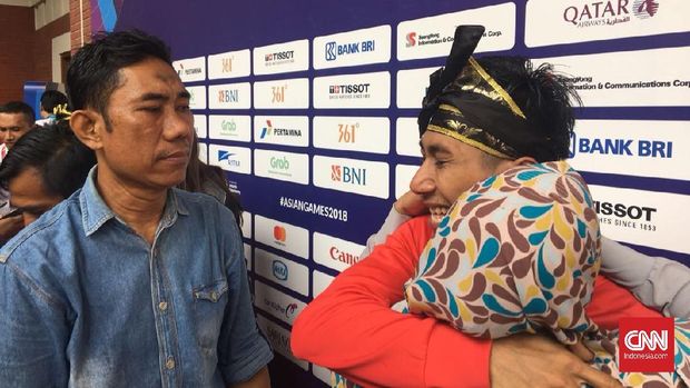 Hendy mendapat pelukan dari Rahmawati setelah mendapat kalungan medali emas.