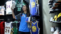 Seorang atlet Thailand menanyakan harga sepatu yang ia buru.