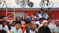 Atlet Balap Sepeda Hong Kong berlatih di trek sementara beberapa jemaah melaksanakan salat Jumat di arena Balap Sepeda Trek Asian Games ke-18 Tahun 2018, Velodrome Rawamangun, Jakarta, Jumat (31/8). ANTARA FOTO/INASGOC/Eka Nickmatulhuda.
