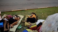 Ini adalah potret anak-anak Venezuela tidur di rumput di depan Stasiun Bus antarnegara di Boa Vista, negara bagian Roraima, Brasil. Nacho Doce/Reuters.