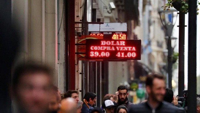 A man walks past a currency exchange board in Buenos Aires financial district, Argentina August 30, 2018. REUTERS/Marcos Brindicci