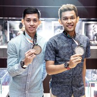 Begini gaya Fajar dan Rian memamerkan medali perak, berikut jam tangan TAG Heuer Carrera Heuer 01. Kemeja biru kotak-kotak menjadi pilihan Rian, sementara rekannya, Fajar, memilih kemeja abu-abu dan celana coklat. (Foto: dok. Time International)