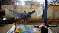 Perempuan Venezuela di dekat tempat tidur mereka selama malam di bengkel mobil. Nacho Doce/Reuters.
