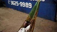 Wanita Venezuela tidur di tempat tidur gantung pada malam hari di bengkel mobil. Nacho Doce/Reuters.