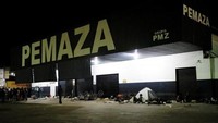 Orang-orang Venezuela beristirahat di malam hari di sebuah toko suku cadang mobil dan sepeda motor. Nacho Doce/Reuters.